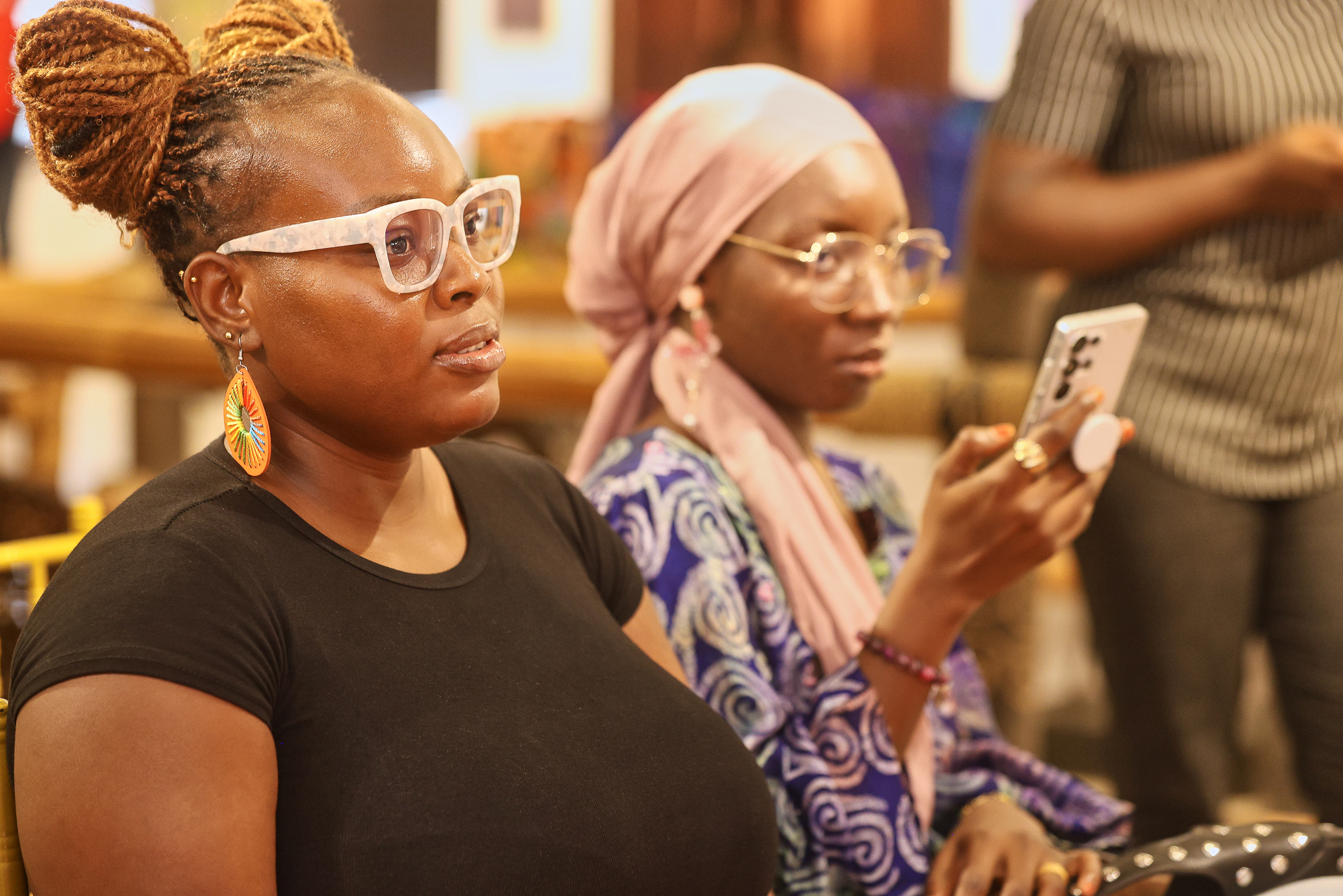 Two ladies listening engaging with the panel conversations 